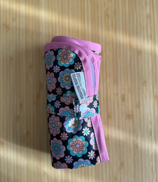 An assortment of colorful cloth diapers neatly stacked, showcasing a sustainable and eco-friendly diapering option for babies. The diapers display various vibrant patterns and soft fabrics, providing a reusable and comfortable solution for families.