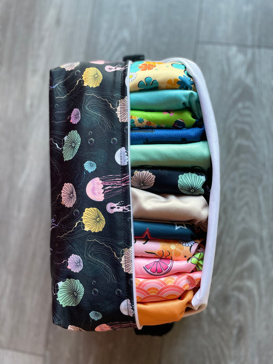 An assortment of colorful cloth diapers neatly stacked, showcasing a sustainable and eco-friendly diapering option for babies. The diapers display various vibrant patterns and soft fabrics, providing a reusable and comfortable solution for families.