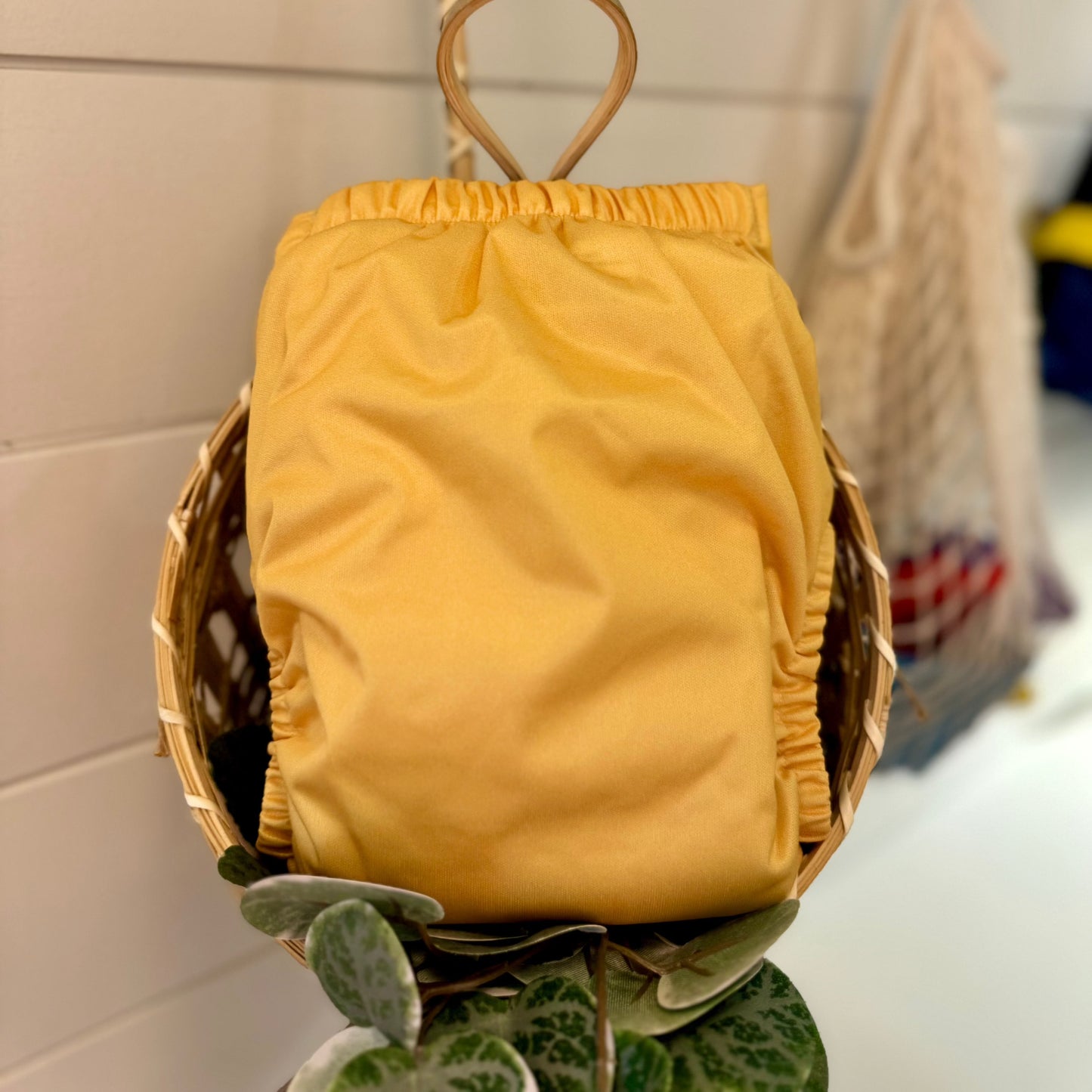 back of yellow cloth diaper in a basket