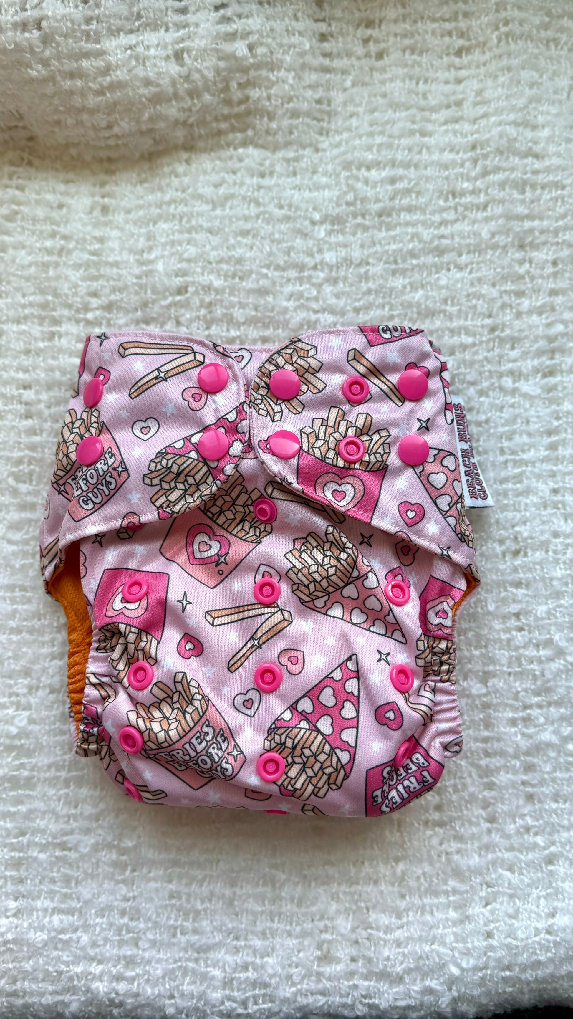 An assortment of colorful cloth diapers neatly stacked, showcasing a sustainable and eco-friendly diapering option for babies. The diapers display various vibrant patterns and soft fabrics, providing a reusable and comfortable solution for families.