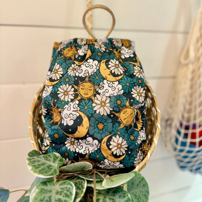 sun, moon, clouds, and floral cloth diaper in a basket