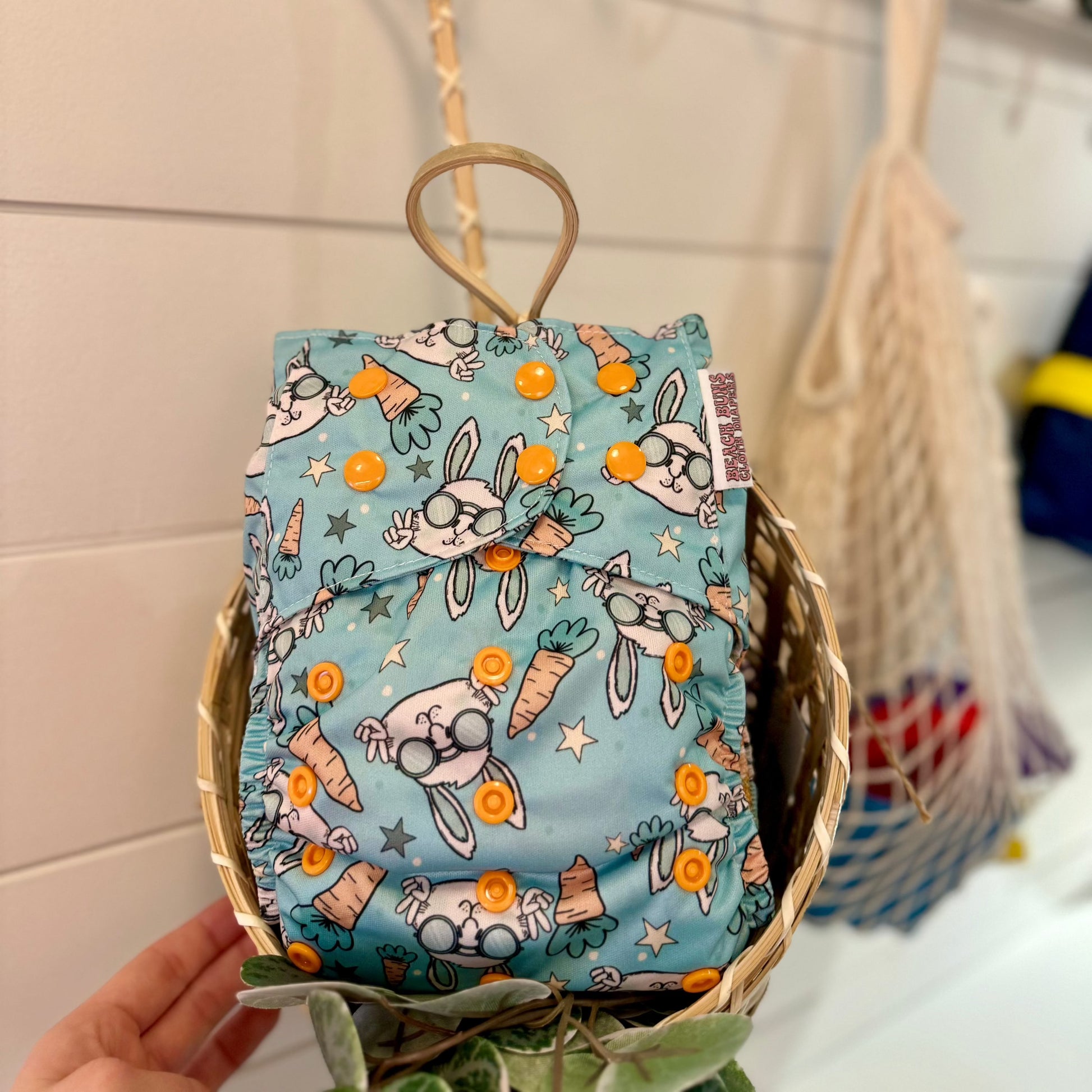 Groovy Bunny Pocket Cloth Diaper with carrots and bunnies and stars in a basket 